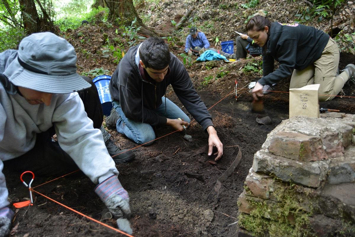 Three students working in a ditch